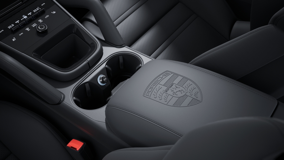 Тисненый герб Porsche на подлокотниках центральной консоли.
